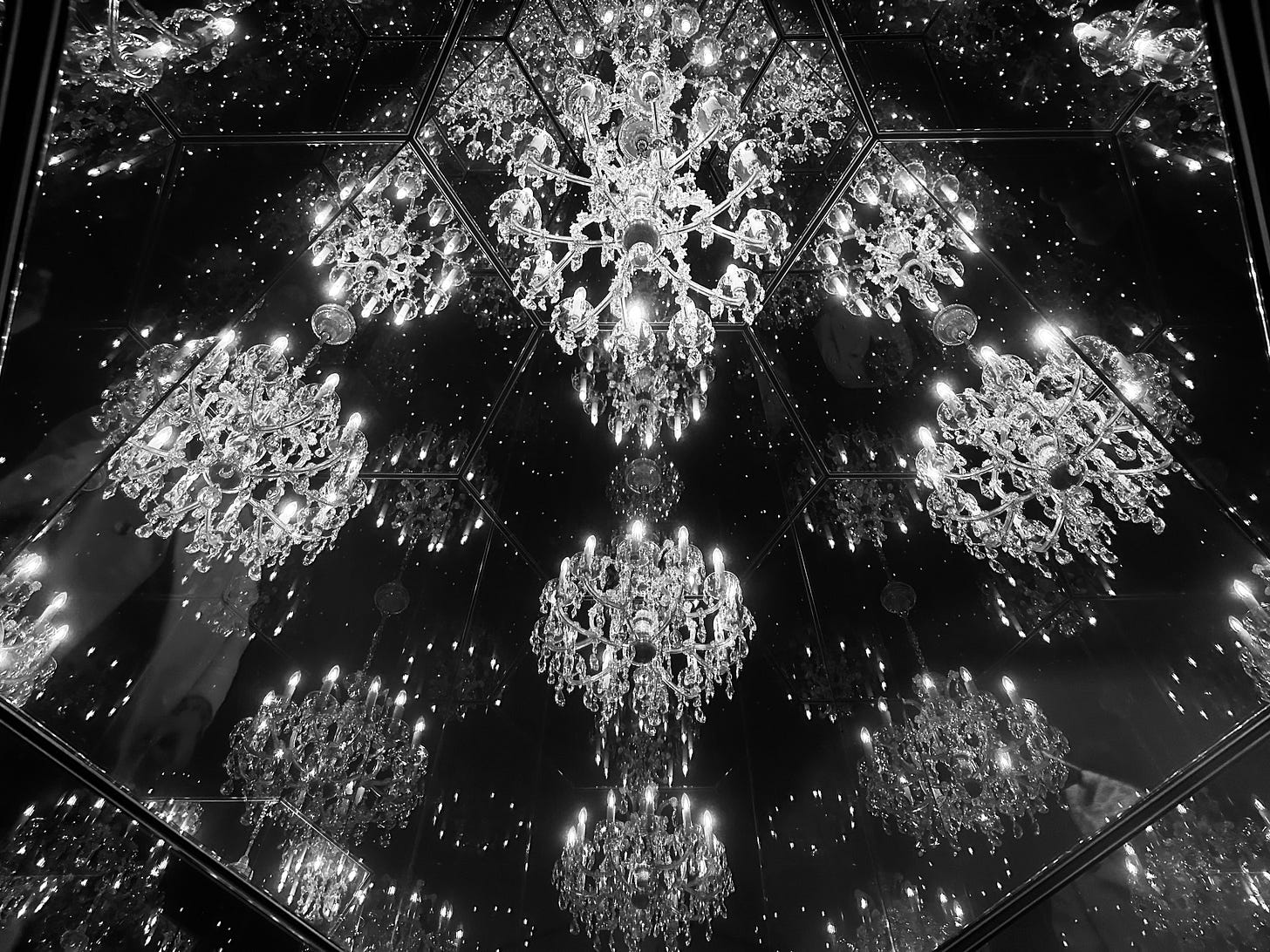 A photo of an ornate chandelier, seen at an angle from below, along with a multitude of reflections from a series of mirrors. A photo of an ornate chandelier, seen at an angle from below, along with a multitude of reflections from a series of mirrors.