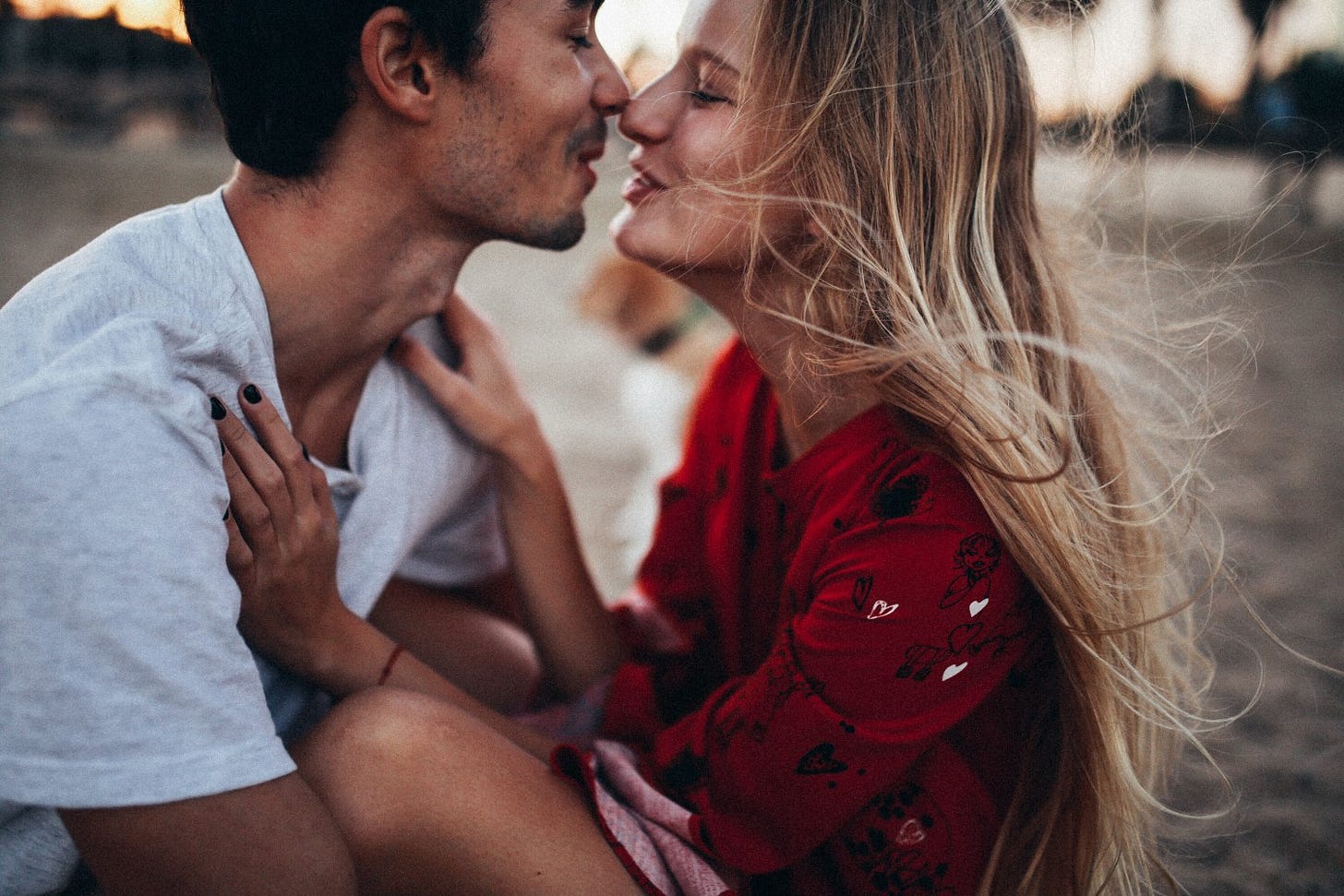 A couple playfully embraces on a beach. A couple playfully embraces on a beach.