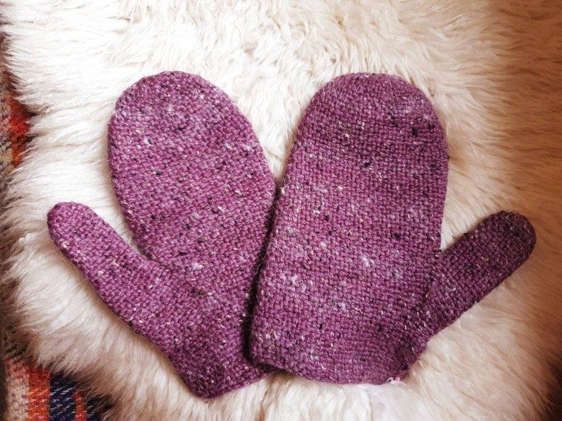 May include: A pair of purple knitted mittens with a speckled texture.