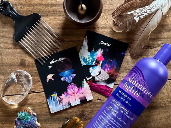 Oracle cards on a wood table. An afro hair pick, an incense holder, a feather a bottle of shampoo and crystals are around them. Oracle cards on a wood table. An afro hair pick, an incense holder, a feather a bottle of shampoo and crystals are around them.