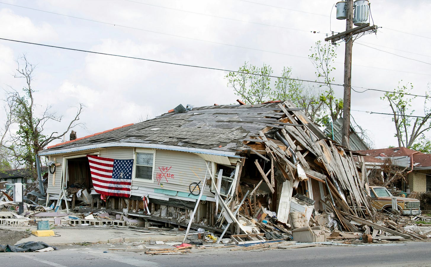 a destroyed wooden house with an American flag a destroyed wooden house with an American flag
