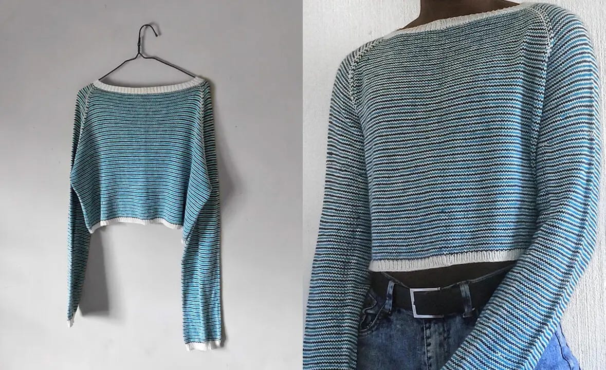 a white, blue and navy striped sweater on a clothes hanger