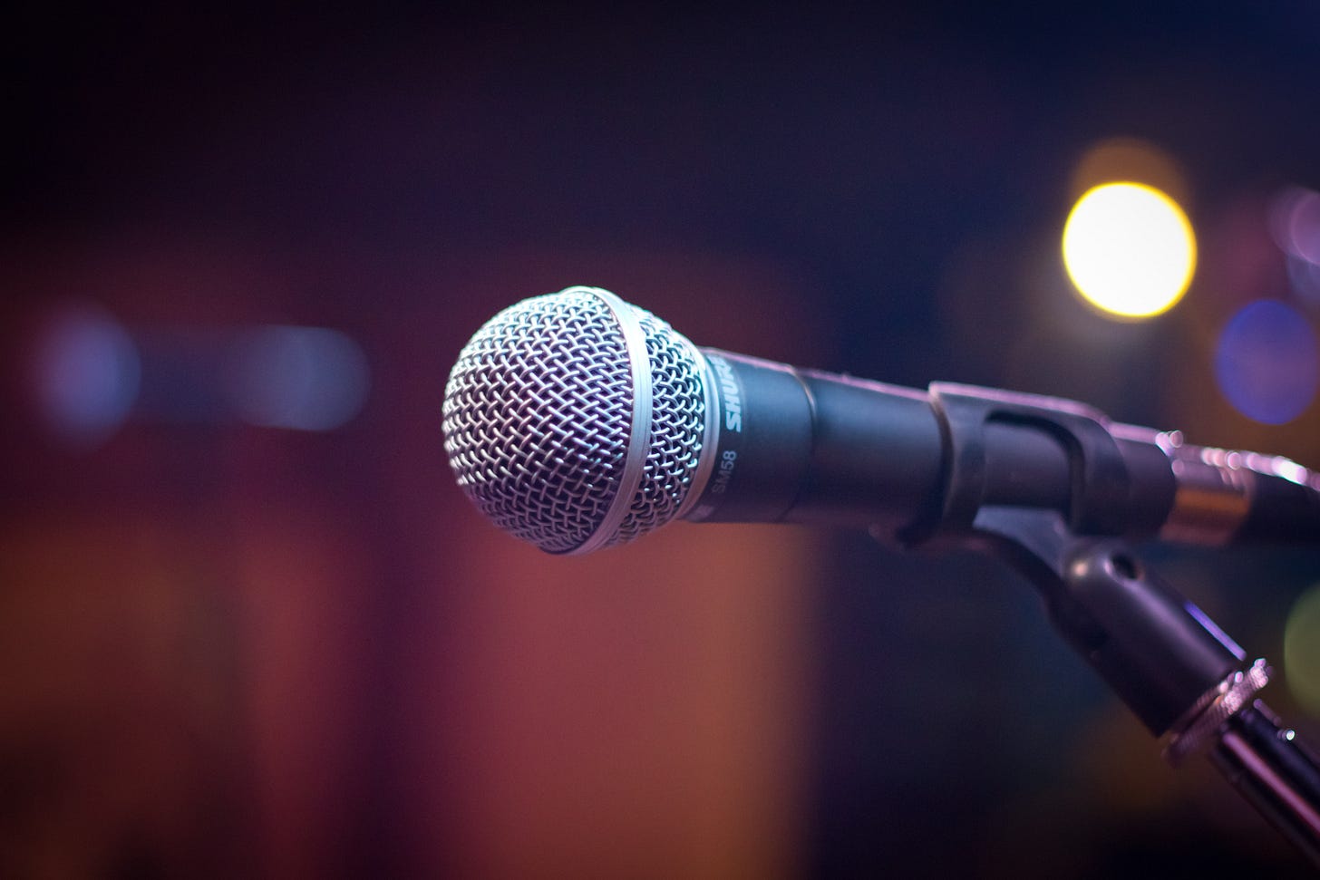 a zoomed in picture of a microphone on a stage. The background is blurred out. a zoomed in picture of a microphone on a stage. The background is blurred out.