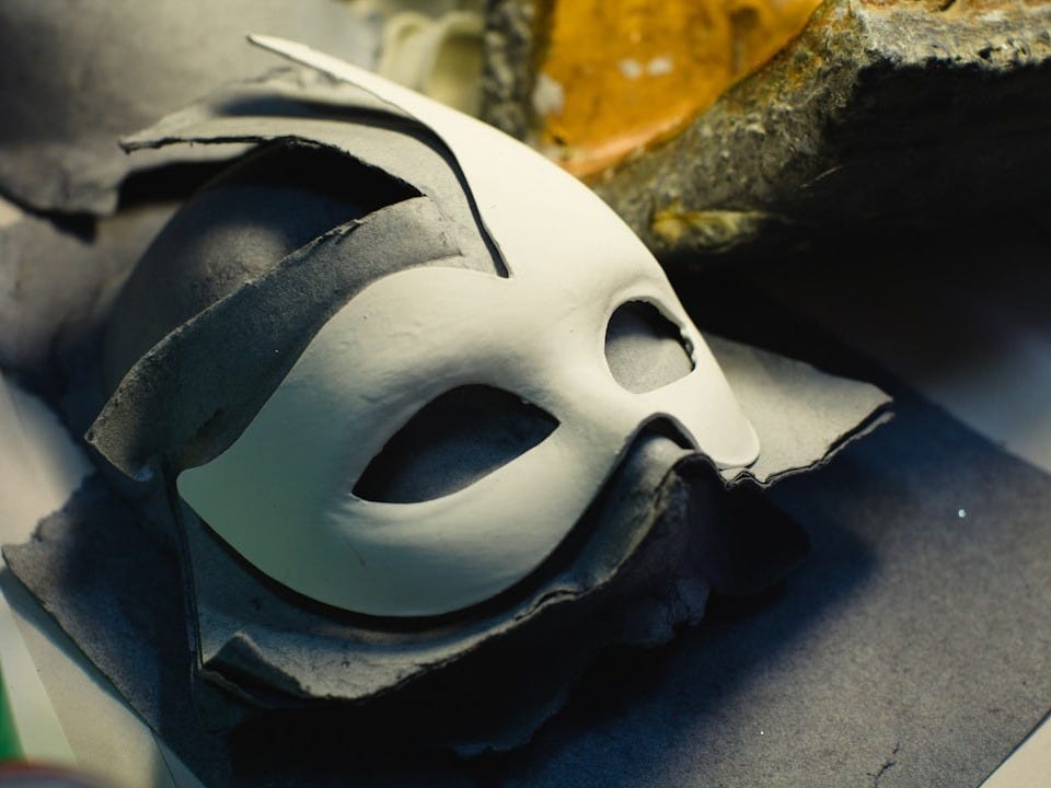 a white mask sitting on top of a piece of paper