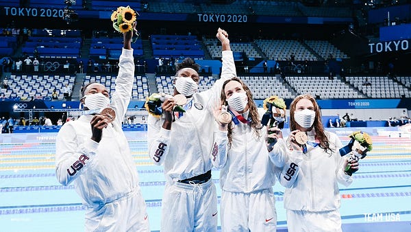 simone manuel, natalie hinds, abbey weitzeil, and erika brown pose with flowers and bronze medals
