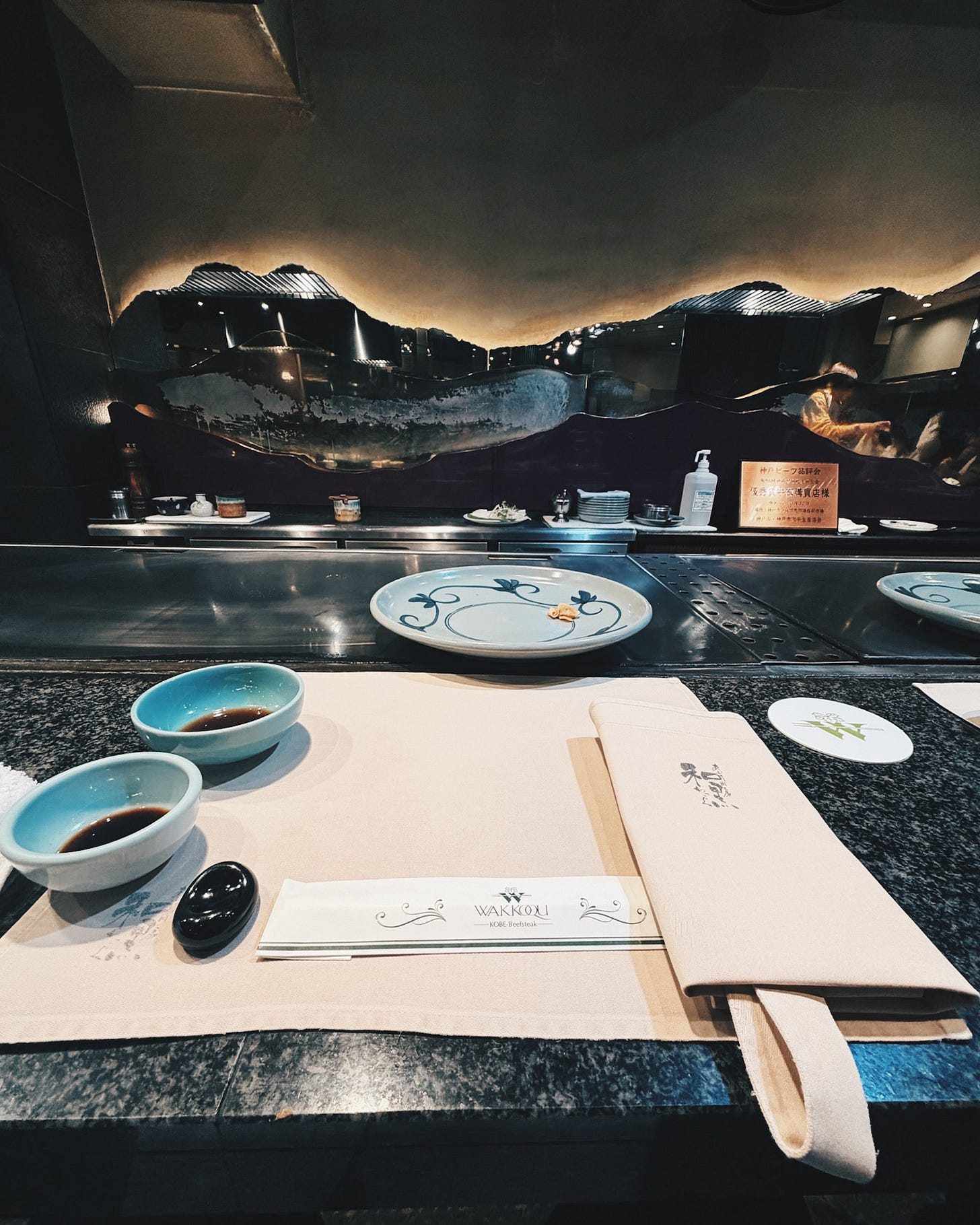 Formal teppanyaki dining setup at Wakkoku restaurant with marble counter and mirrored mountain centerpiece, Kobe Formal teppanyaki dining setup at Wakkoku restaurant with marble counter and mirrored mountain centerpiece, Kobe