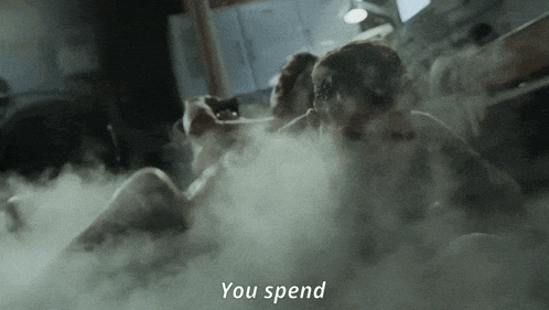 a man and woman are laying in a bathtub with smoke coming out of them and the words " you spend " above them