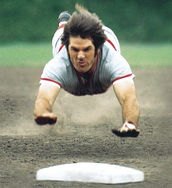Pete Rose sliding into home base while caught lying.