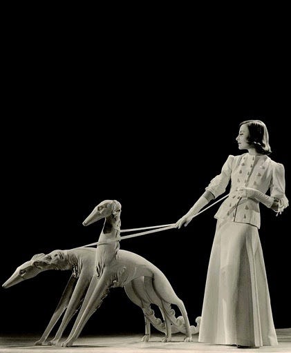 This may contain: a woman is walking two dogs on a leash in black and white photo with the dog pulling her