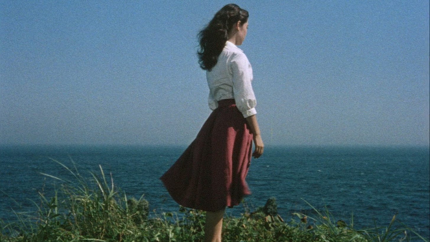 The Blue Sky Maiden | Still features Ayako Wakao looking over the sea.