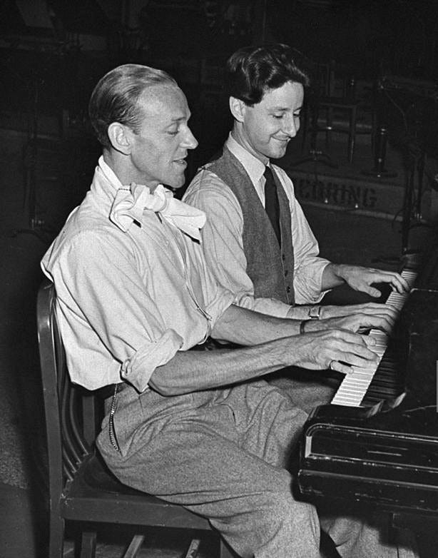 FRED ASTAIRE — Fred Astaire playing the piano with his...