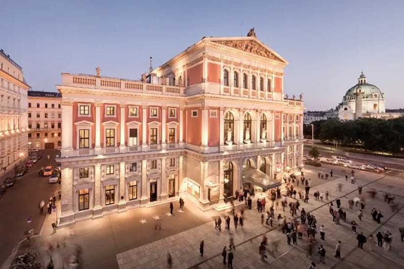 A large building with many people in front of it

Description automatically generated