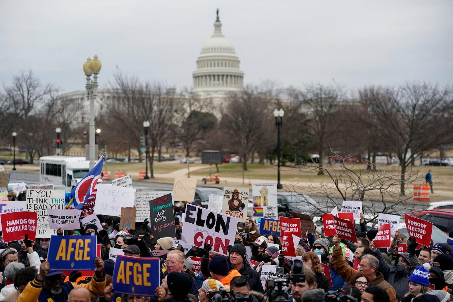 Demonstrators rally during a protest against U.S. President Donald Trump and the actions he has taken in the first weeks of his presidency that pose threats to US democracy, outside of the Department of Labor (not pictured) in Washington, U.S., February 5, 2025. Demonstrators rally during a protest against U.S. President Donald Trump and the actions he has taken in the first weeks of his presidency that pose threats to US democracy, outside of the Department of Labor (not pictured) in Washington, U.S., February 5, 2025.
