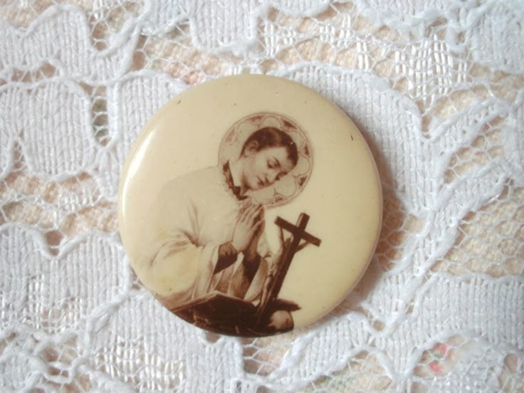 This may contain: a button with an image of a woman holding a cross on it's lap