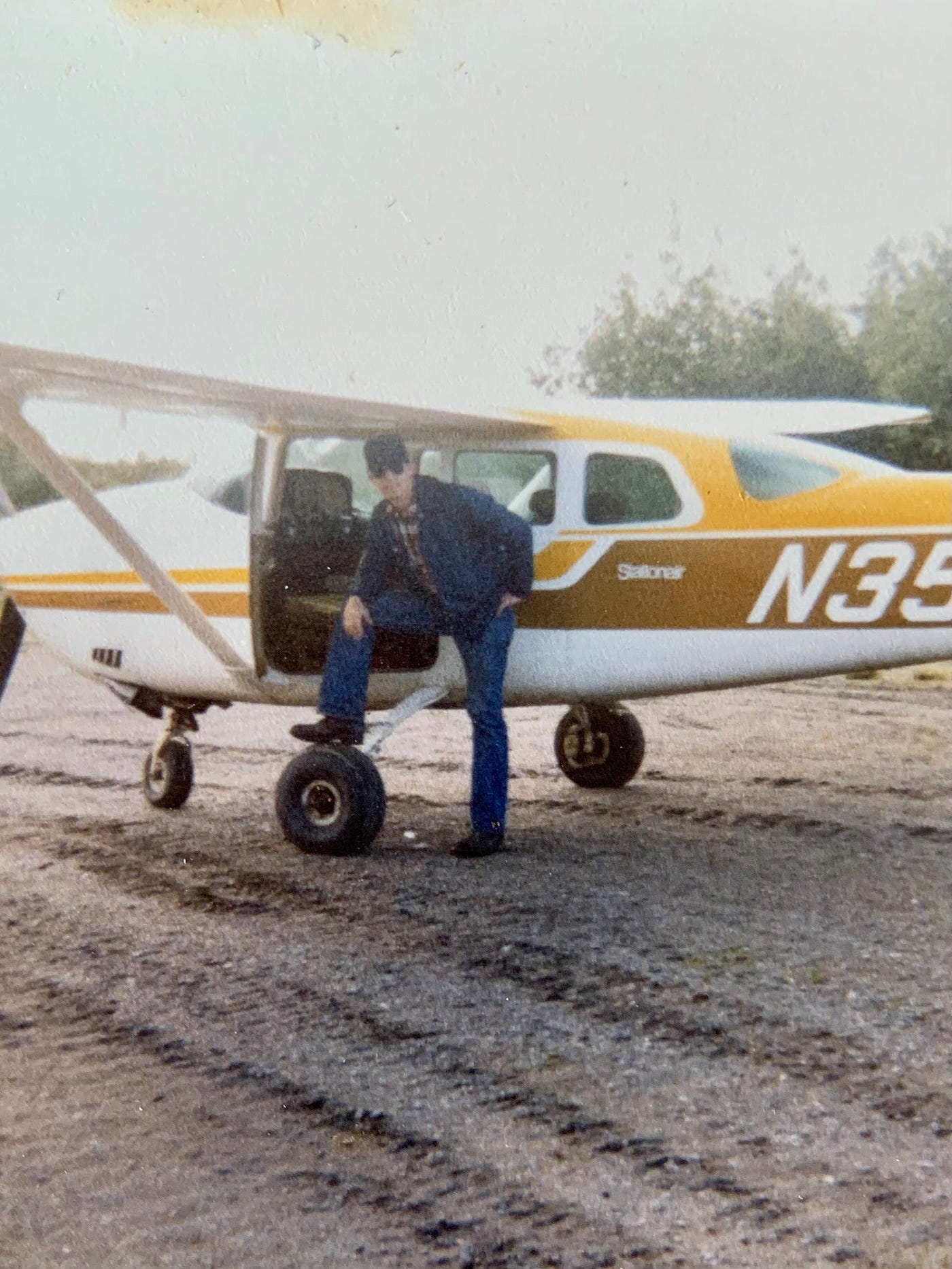 The author pictures himself standing outside of the plane he flew in the Alaskan Bush.