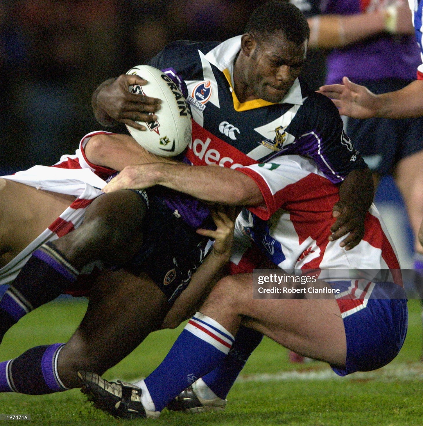 Marcus Bai of the Storm is tackled by the Storm defence