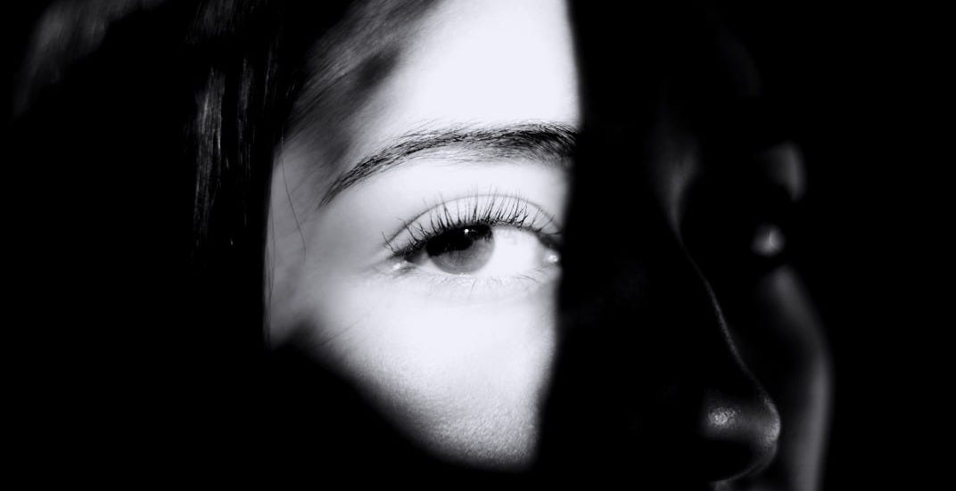 Dramatic black and white close-up of a person's face.