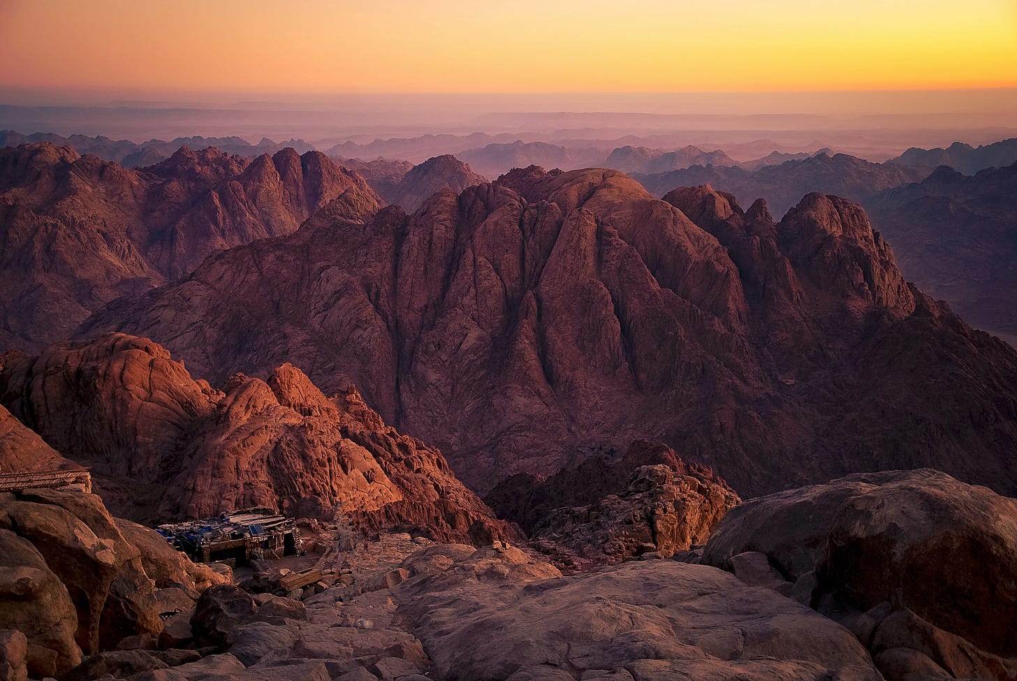 The sun sets over a mountain range, with Mount Sinai centered in the view.