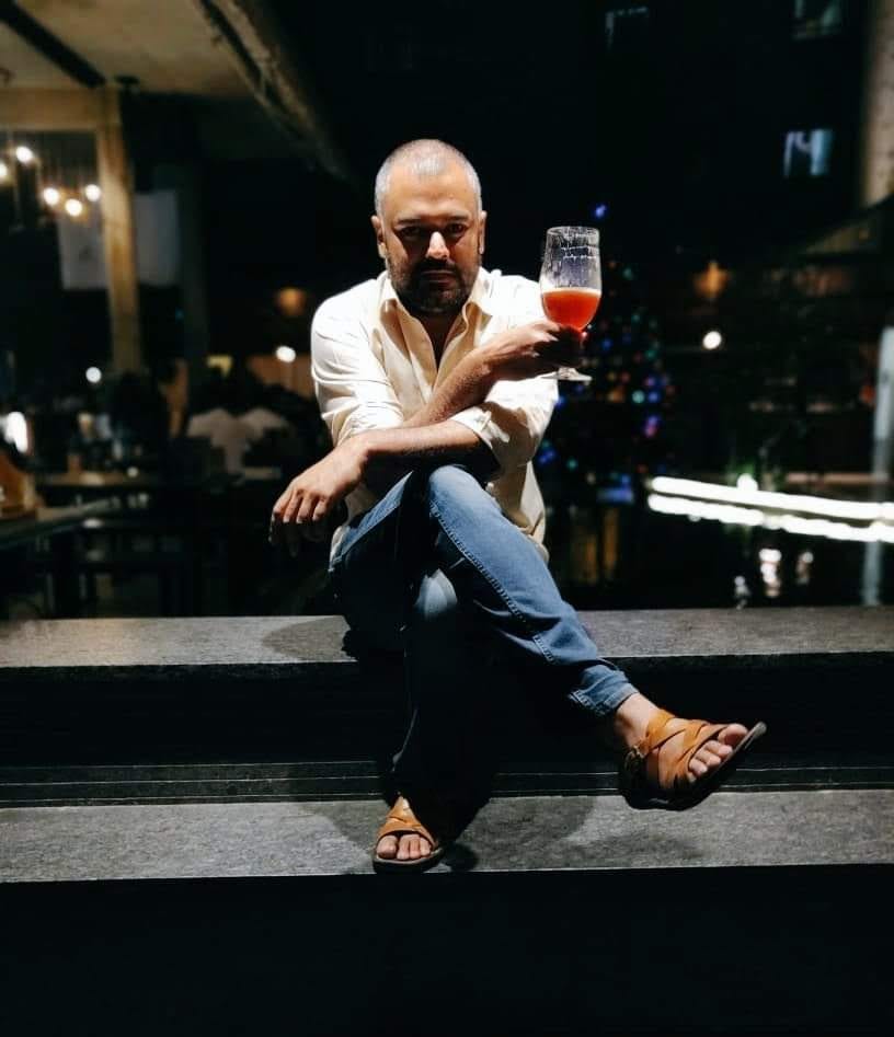 A man sitting on steps with a wine glass in his hands