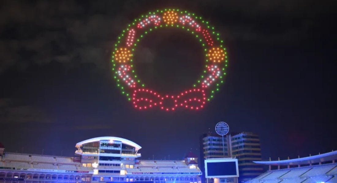 A night sky with drone lights in a wreath shape and Trent Bridge below it