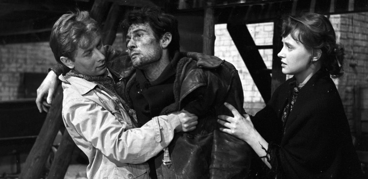 As a woman played by an unidentified actress looks on, Fiałka (Władysław Kowalski) supports a badly beaten Jakub (Serge Merlin).