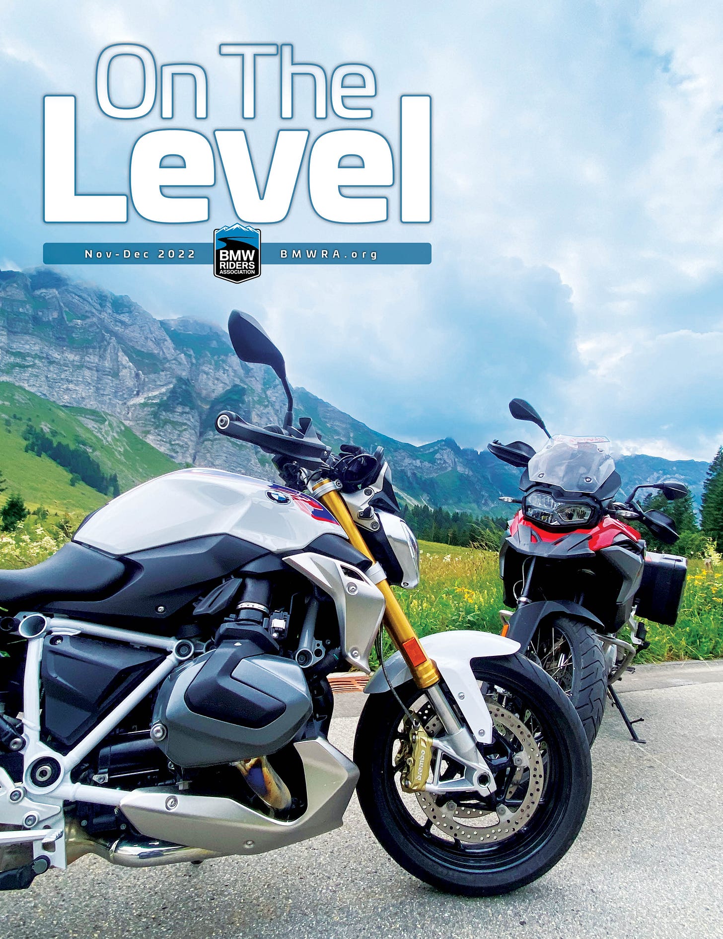 Two BMW motorcycles, white and red, in the Swiss Alps