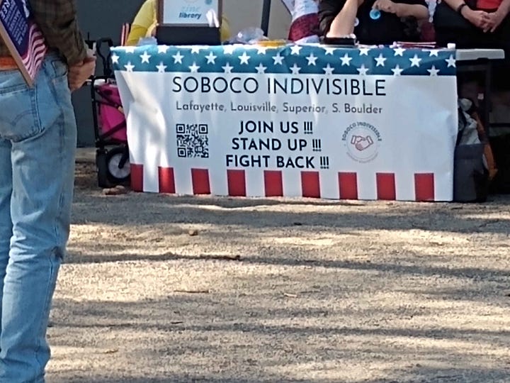 From top left, clockwise: a woman in a cowboy hat and a pink vest holds a sign reading "End The Trump Chaos Cruelty Corruption, Vote Blue in 2026, Impeach the Grifter-in-chief, a choral group with sound equipment and songsheets performs in a half-shell - they have a banner identifying themselves as the Singing Resistance: Boulder; a banner at a table for Soboco Indivisible, modeled after the American flag, reading Join Us, Stand Up, Fight Back; a large crowd of protesters gathered along the street.