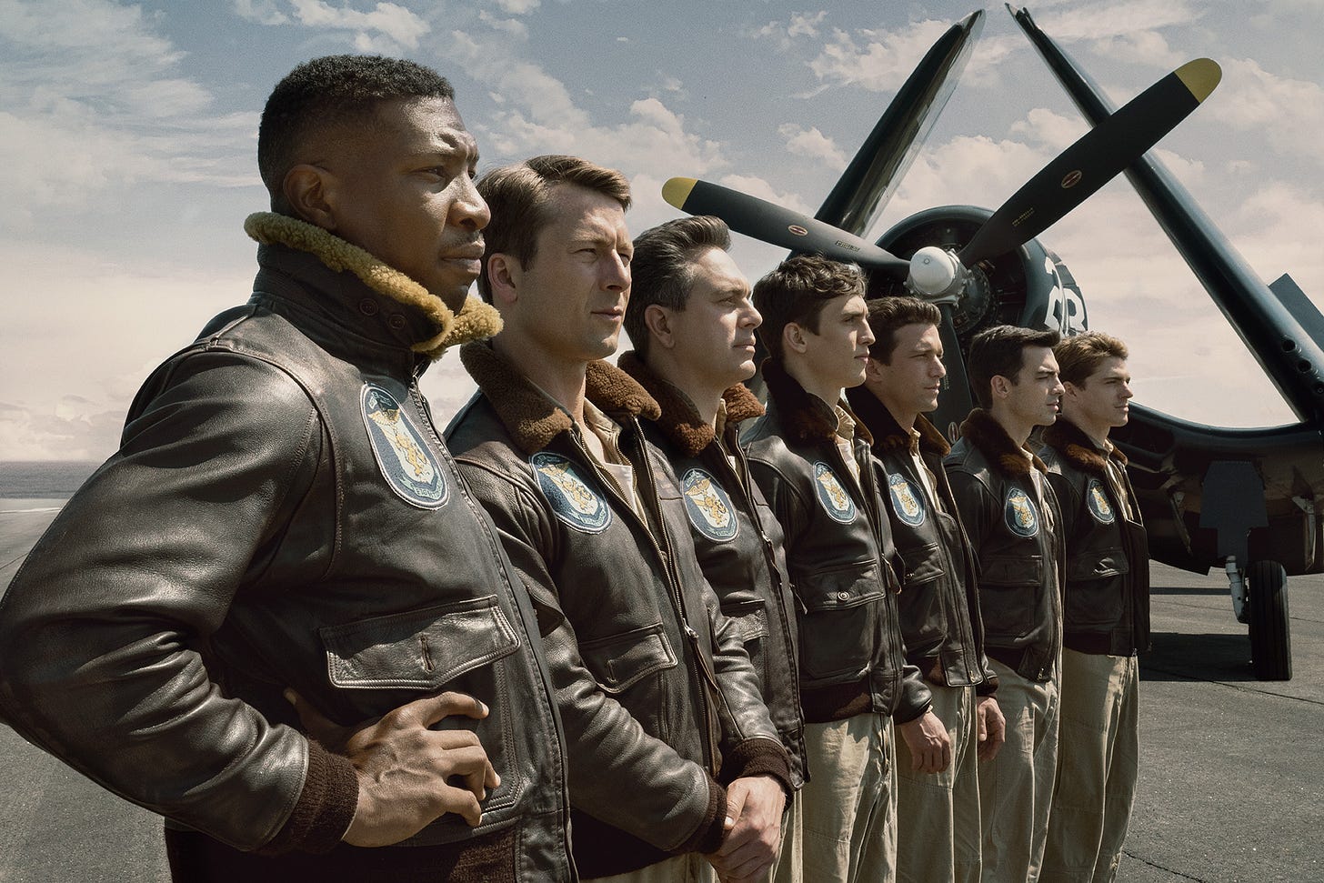 Film still for DEVOTION featuring Jesse Brown (Jonathan Majors), Tom Hudner (Glen Powell), Dick Cevoli (Thomas Sadoski), Carol Mohring (Nick Hargrove), Bill Koenig (Daren Kagasoff), Marty Goode (Joe Jonas) and Bo Lavery (Spencer Neville) all lined up in front of a Corsair. Film still for DEVOTION featuring Jesse Brown (Jonathan Majors), Tom Hudner (Glen Powell), Dick Cevoli (Thomas Sadoski), Carol Mohring (Nick Hargrove), Bill Koenig (Daren Kagasoff), Marty Goode (Joe Jonas) and Bo Lavery (Spencer Neville) all lined up in front of a Corsair.