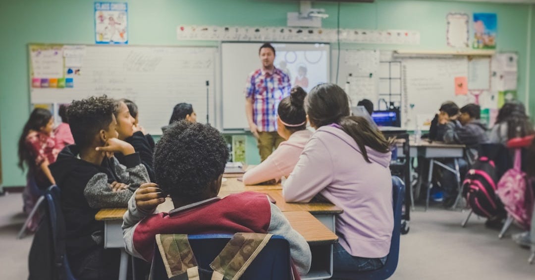 students in classroom with teacher presenting students in classroom with teacher presenting