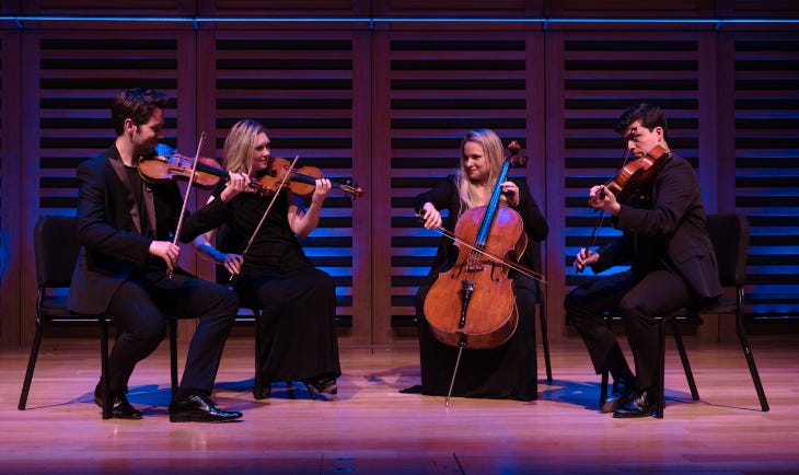 A string quartet performing on stage A string quartet performing on stage
