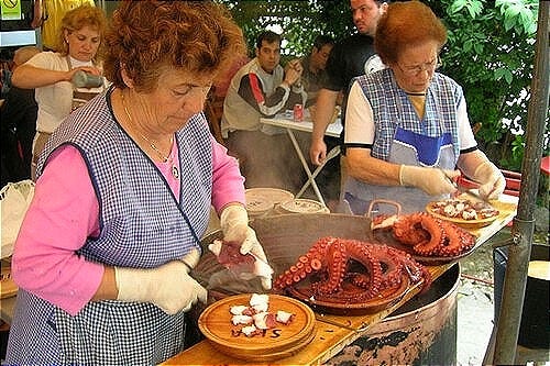 Ambiente festivo con pulpeiras y gente disfrutando en una feria gallega