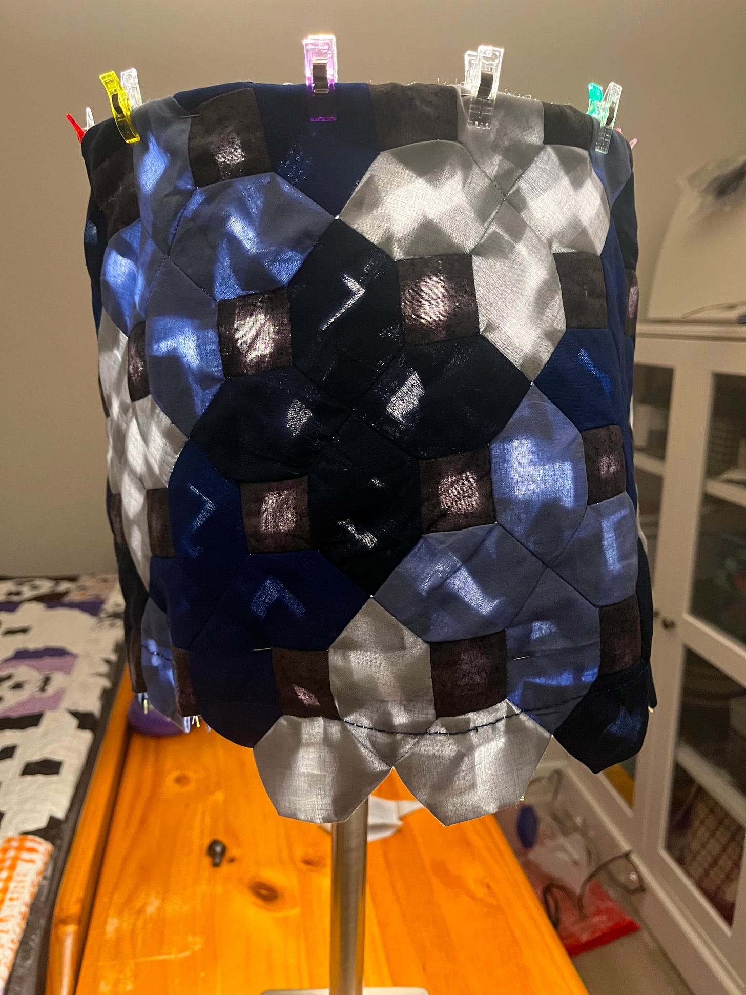 Photo of a patchwork lampshade with light shining through unevenly due to the seam allowances