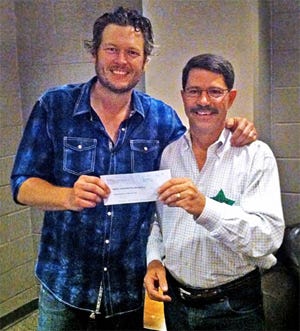 Country music star Blake Shelton hands a check for $20,000 to Richard Hatcher, director of the Wildlife Department after an Oct. 4 concert in Tulsa. Shelton donated the money to the Wildlife Department to support the agency's suite of outdoor education programs Country music star Blake Shelton hands a check for $20,000 to Richard Hatcher, director of the Wildlife Department after an Oct. 4 concert in Tulsa. Shelton donated the money to the Wildlife Department to support the agency's suite of outdoor education programs