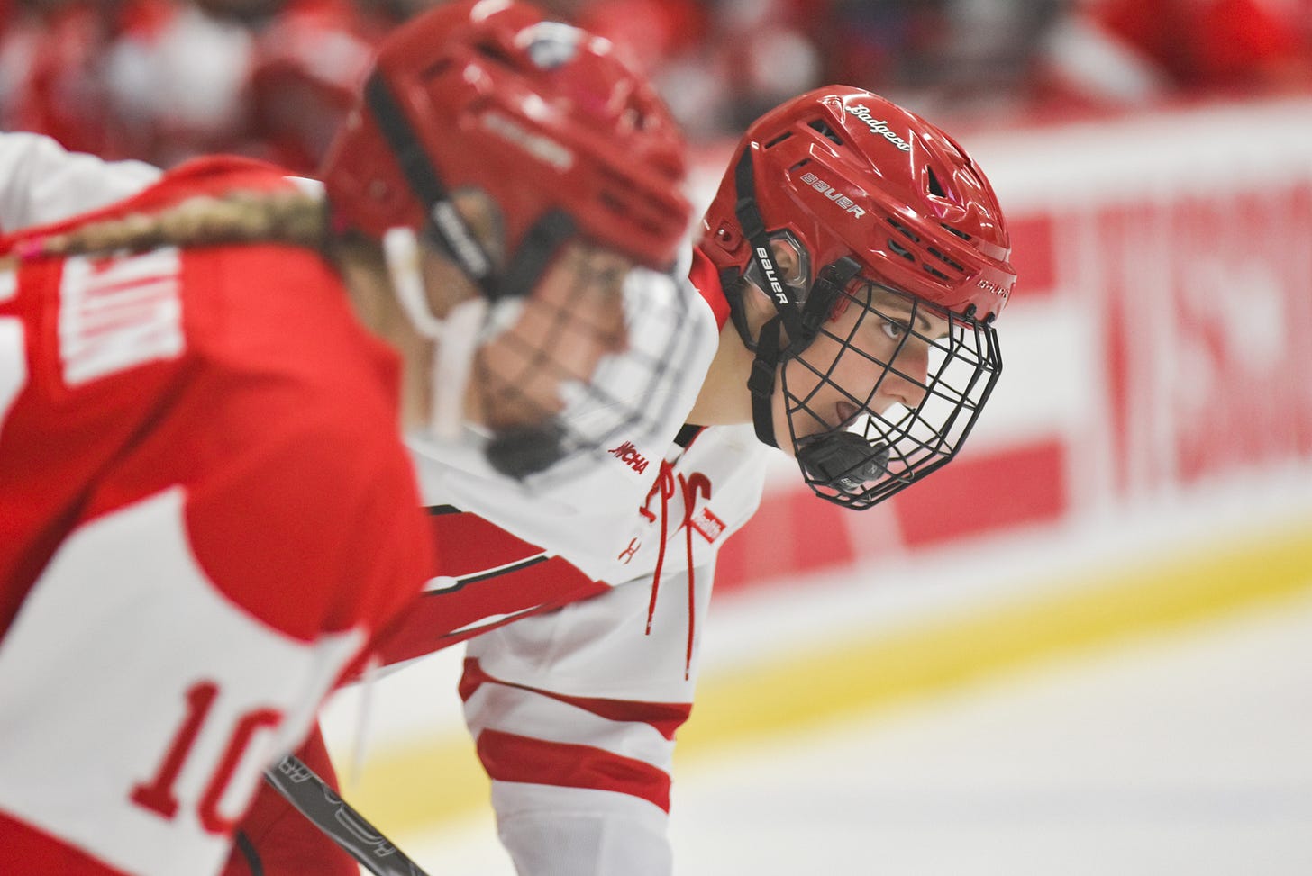 Wisconsin women's hockey winger Kelly Gorbatenko in focus in front of a Boston University player waiting for the puck to drop