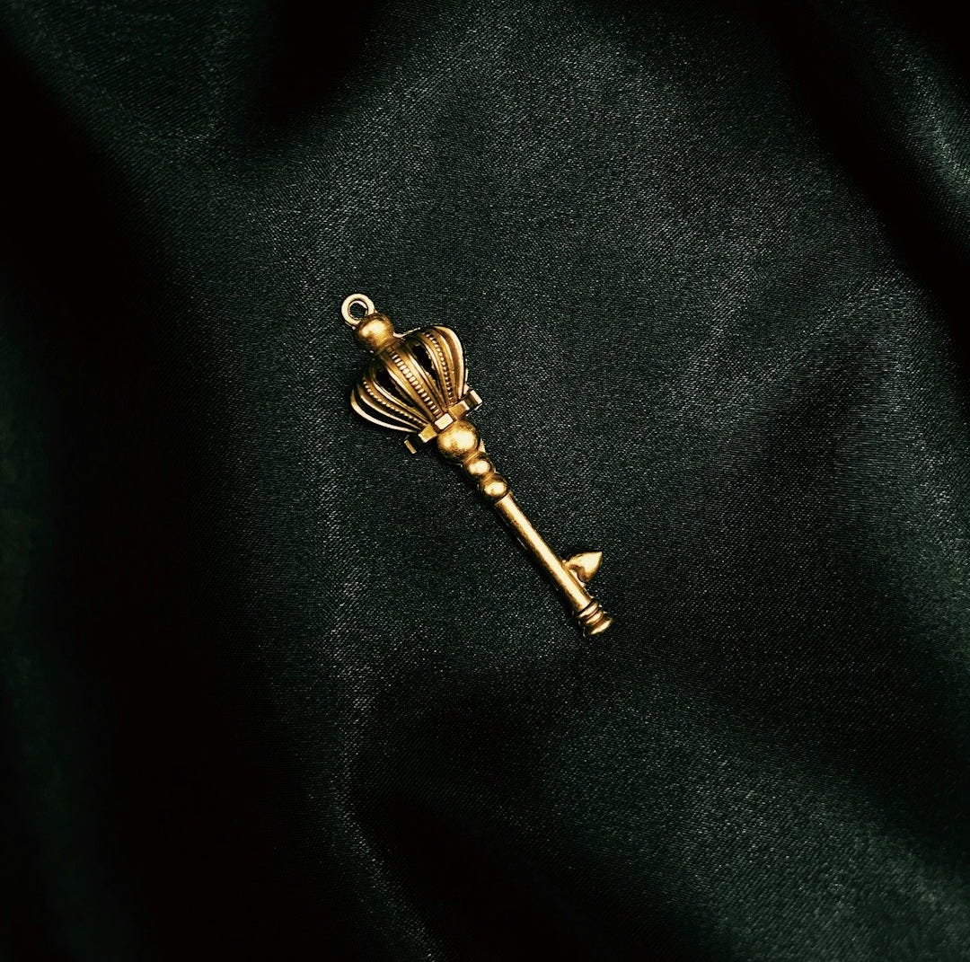 a gold key on a black surface a gold key on a black surface