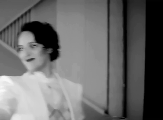 A continuation of the previous gif. Phoebe reaches the end of the staircase and swings around the knob at the end of the bannister whilst casually taking a sip of her martini.