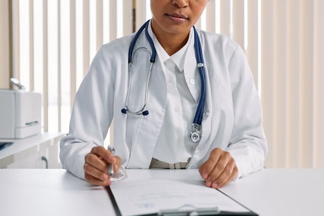 Photograph of a doctor in an office with a clipboard