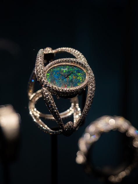 An antique opal and diamond watch in the Flames of Opal Essence exhibition, a ring by Sharvash Hakobian, a dragonfly brooch by Chong Ho, a brooch at Strong & Precious, a necklace by Jaqueline Powers, a ring by William Llewellyn Griffiths, all on show at GemGenève.