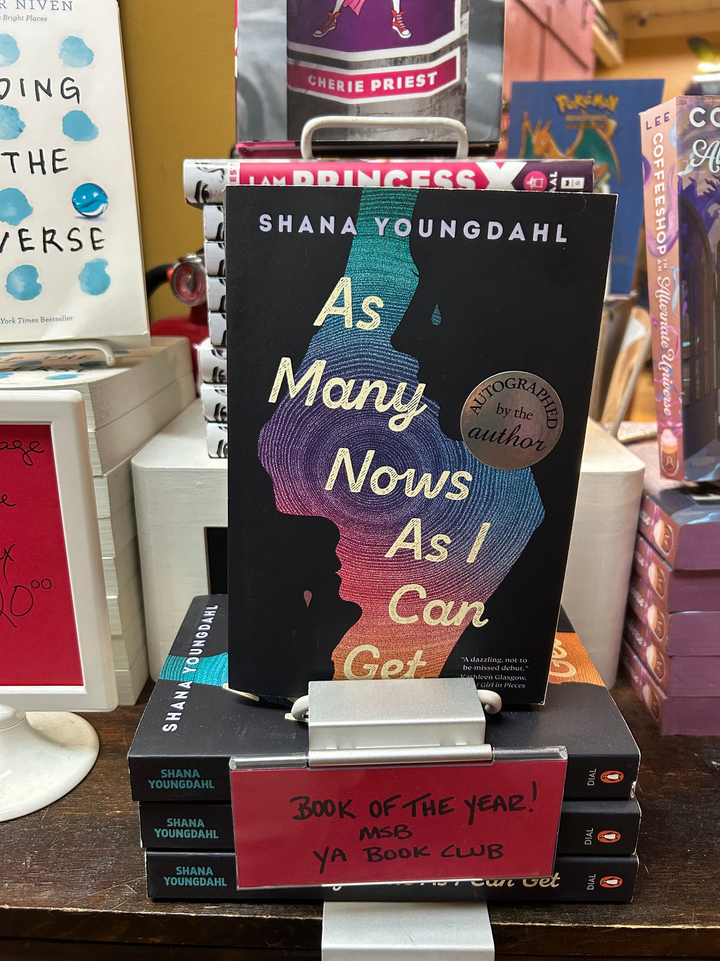 A picture of the book As Many Nows As I Can Get by Shana Youngdahl on a table with a 2025 YA Book Club Pick of the Year annoucement A picture of the book As Many Nows As I Can Get by Shana Youngdahl on a table with a 2025 YA Book Club Pick of the Year annoucement