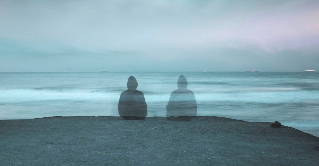 3 white and gray stone on black sand near body of water during daytime