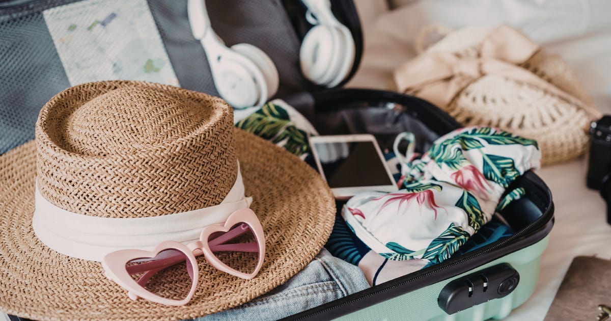 Open suitcase filled with essentials. Photo courtesy of Chirila Sofia via Canva.