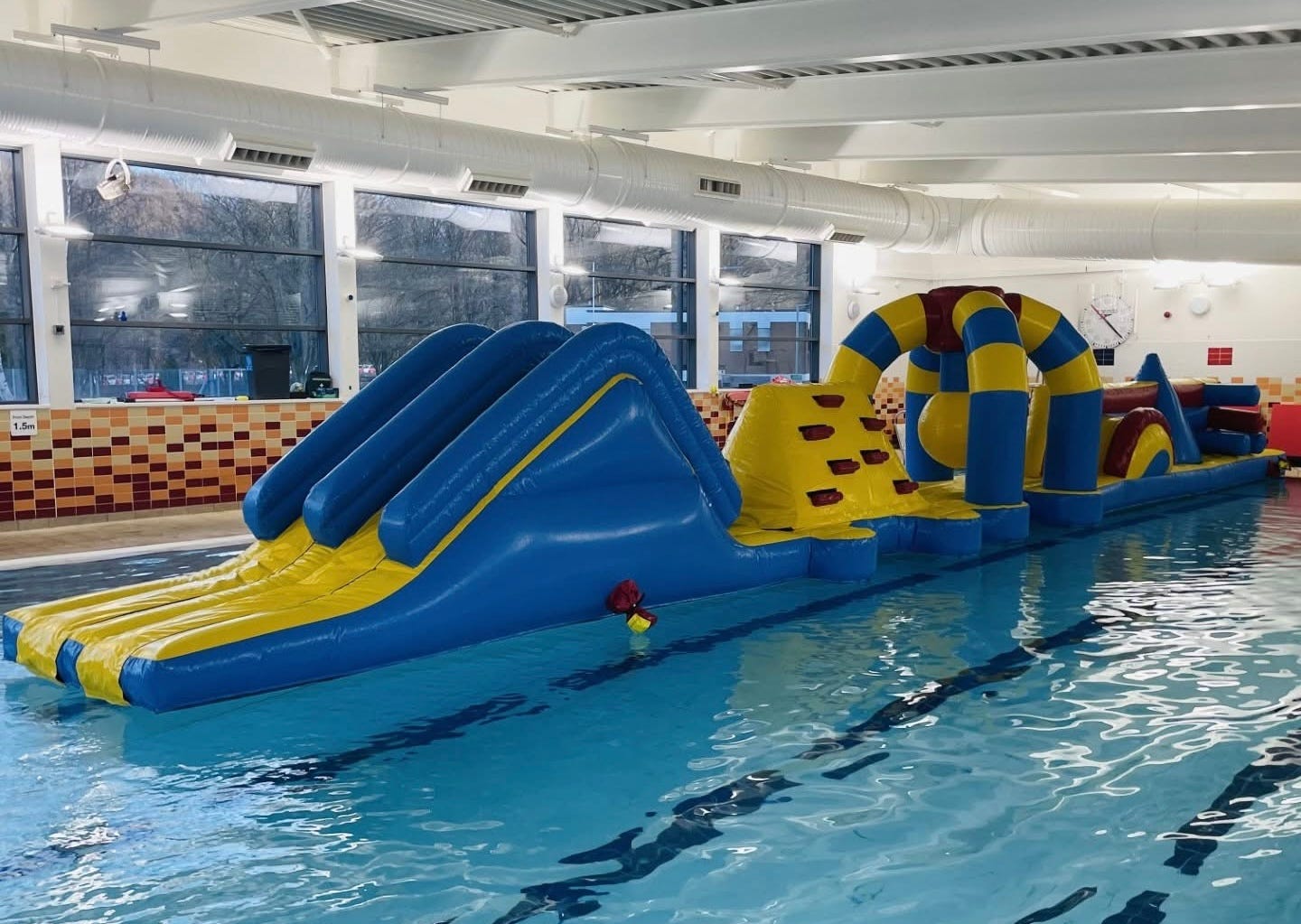 Photograph of a giant inflatable obstacle course in a swimming pool