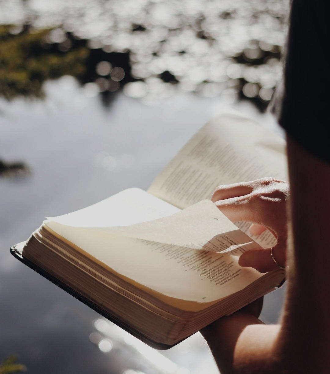 person in black long sleeve shirt holding book person in black long sleeve shirt holding book