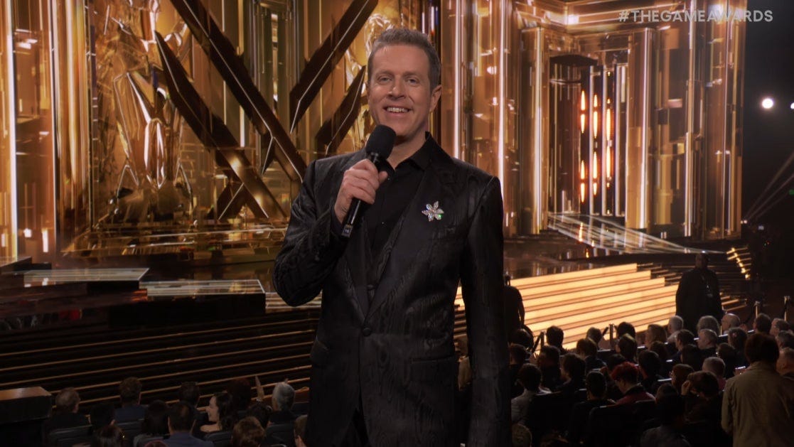 Host Geoff Keighley smiles, holding a mic 