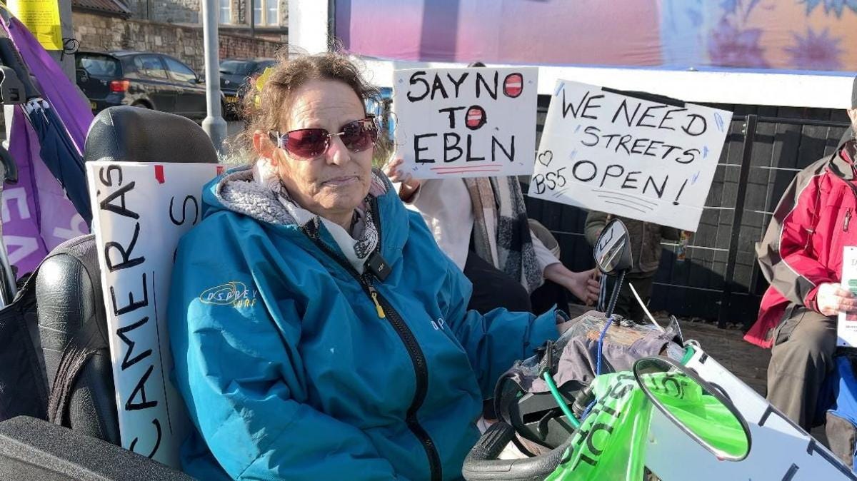 East Bristol resident on mobility scooter at EBLN LTN protest, Barton Hill Bristol, holding Say No To EBLN sign, East Bristol Liveable Neighbourhood campaign 2026 — TheAlmightyGob.com East Bristol resident on mobility scooter at EBLN LTN protest, Barton Hill Bristol, holding Say No To EBLN sign, East Bristol Liveable Neighbourhood campaign 2026 — TheAlmightyGob.com