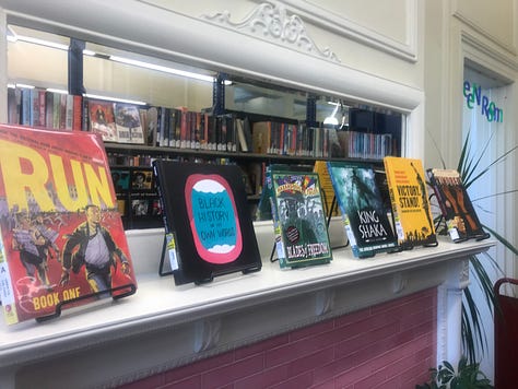 Displays of books including themes like "Black Joy," "Black Future Month," "Graphic Novel Black History Month," "All You Need Is Love?" and "Fighting Together Is Greater Than Fighting Each Other"