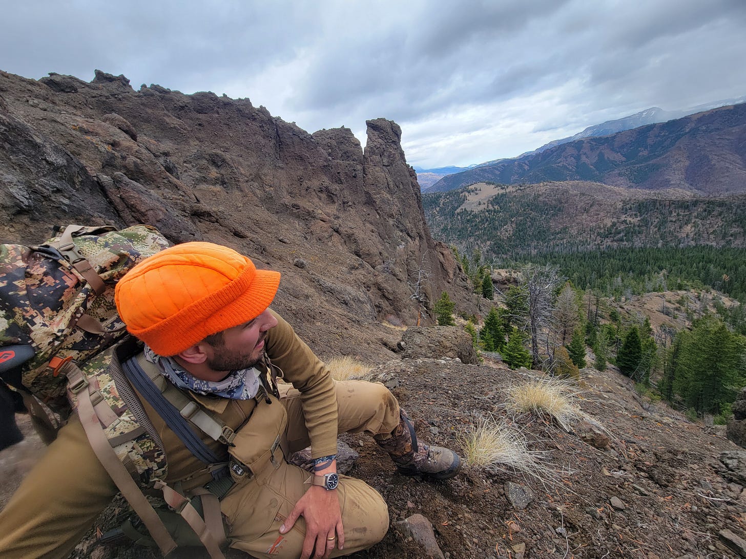 Hunter sitting on the side of a mountain in Wyoming with an orange hat on. Hunter sitting on the side of a mountain in Wyoming with an orange hat on.
