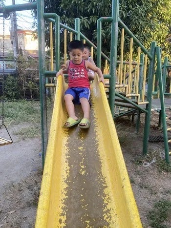 Miguel and Rafa on a slide in a local park Miguel and Rafa on a slide in a local park