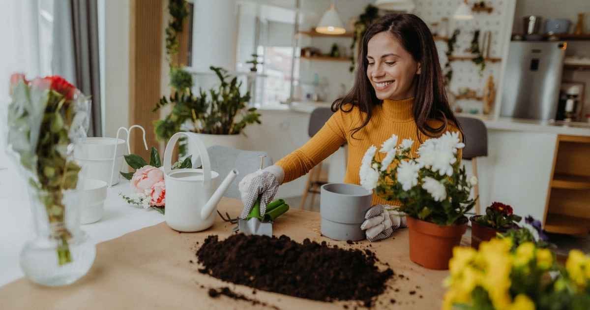 Horticulture hobby. Woman planting and watering flowers at home Horticulture hobby. Woman planting and watering flowers at home