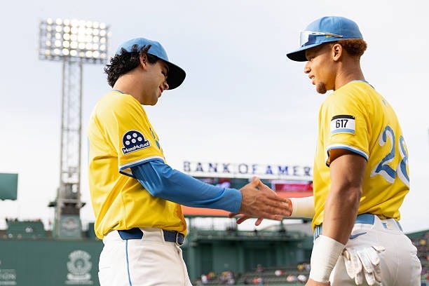 Marcelo Mayer of the Boston Red Sox high-fives Kristian Campbell in his Major League Baseball debut prior to the game between the Baltimore Orioles...